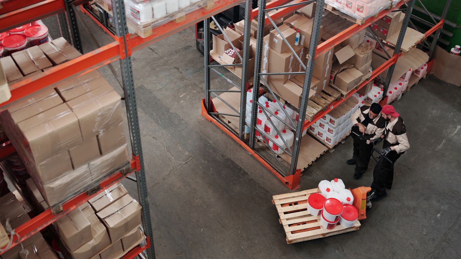 Workers in a warehouse reviewing inventory on shelves